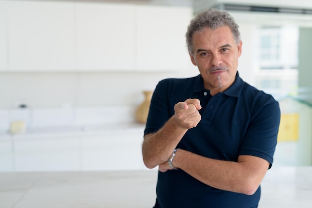 Portret van een man die tegen de muur staat