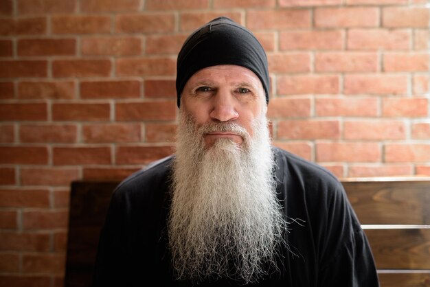 Foto portret van een man die tegen een bakstenen muur staat