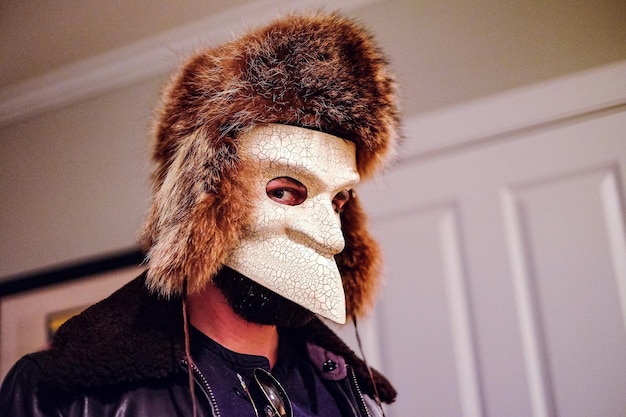 Foto portret van een man die thuis een masker draagt