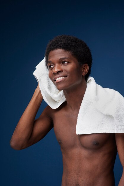 Foto portret van een man die zijn haar droogt met een handdoek