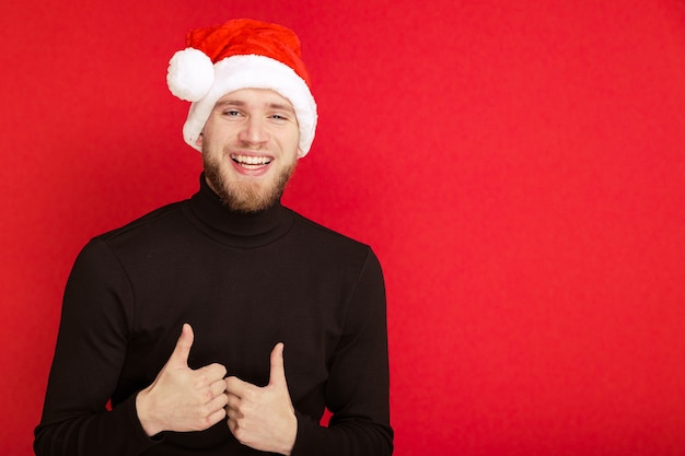 Portret van een man met een kerstmuts die met zijn vingers laat zien dat alles goed is