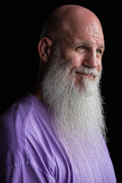 Portret van een man met een lange grijze baard met een paarse t-shirt close-up shot