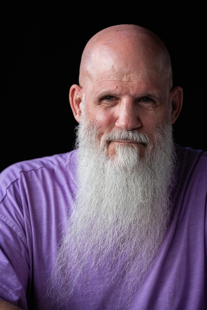 Portret van een man met een lange grijze baard met een paarse t-shirt close-up shot