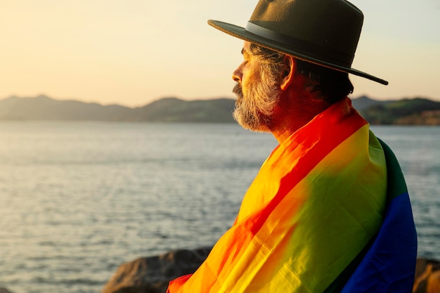 Portret van een man met een lgtbi-trotsvlag in het licht van zonsopgang