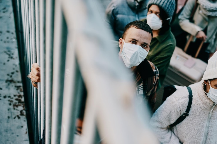 Foto portret van een man met een masker die bij de reling staat