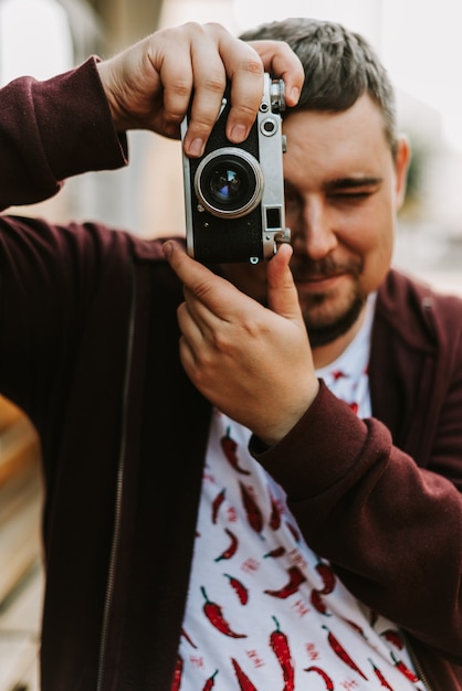 Portret van een man met een retro camera