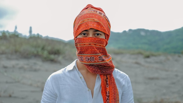 Foto portret van een man met een sjaal die op het veld tegen de lucht staat