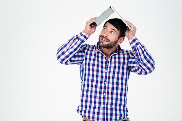 Portret van een man met laptop op zijn hoofd als dak van huis geïsoleerd op een witte muur