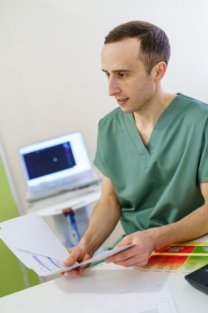 Portret van een mannelijke arts in medische kast. Vrouw die naar de camera kijkt en glimlacht. Moderne apparatuur achtergrond.