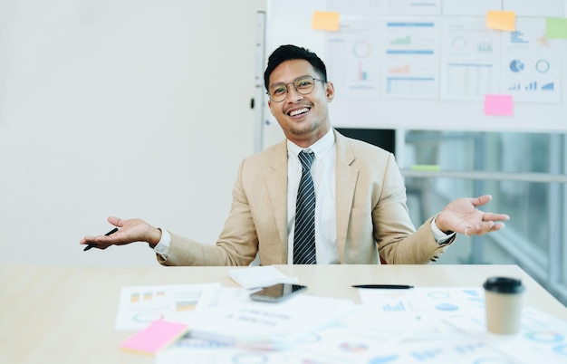 Portret van een mannelijke bedrijfseigenaar die een blij lachend gezicht toont terwijl hij met succes zijn bedrijf heeft geïnvesteerd met behulp van computers en financiële begrotingsdocumenten op het werk