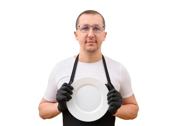 Portret van een mannelijke chef-kok met een bord in zijn handen kijkend naar de camera op een witte achtergrond