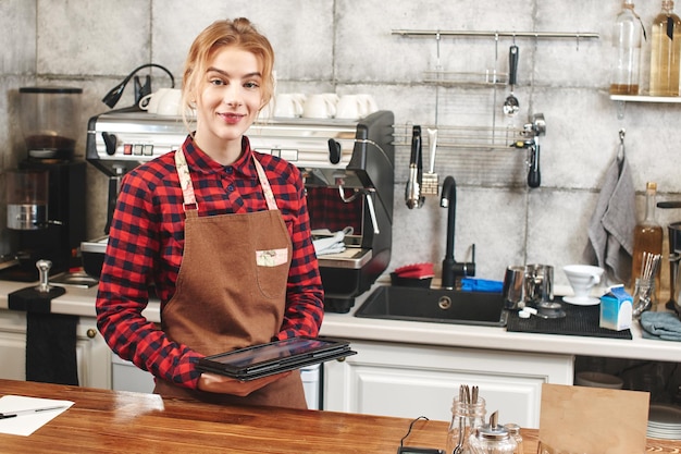 Portret van een meisje barista's op de werkplek op de achtergrond van koffie
