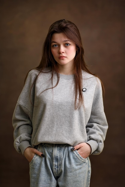 Portret van een meisje close-up een meisje op een bruine achtergrond een mooie look