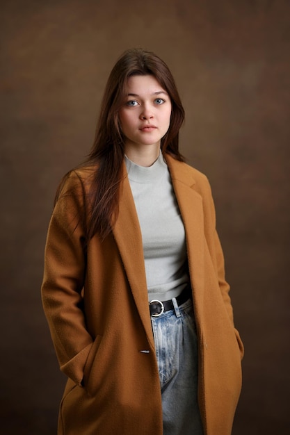Portret van een meisje close-up een meisje op een bruine achtergrond een mooie look