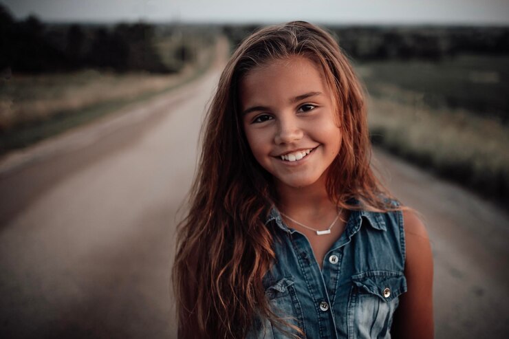 Foto portret van een meisje dat bij zonsondergang op de weg staat