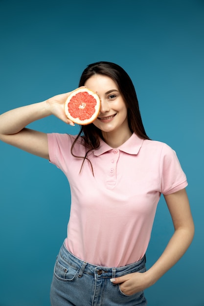 Portret van een meisje dat de helft van grapefruit