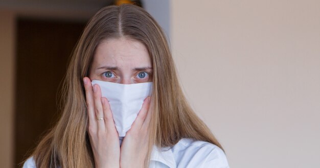 Portret van een meisje dat haar gezicht bedekt met een masker.