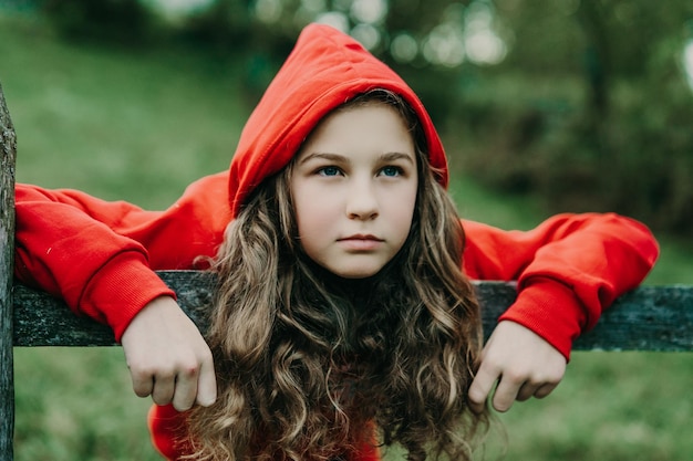 Portret van een meisje dat op een houten hek leunt