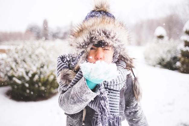Portret van een meisje dat sneeuw blaast tijdens de winter