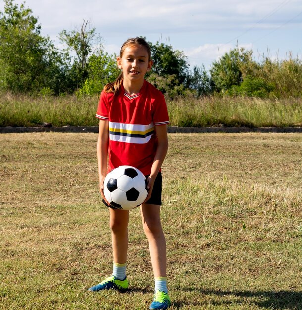 Foto portret van een meisje dat voetbal speelt op het veld