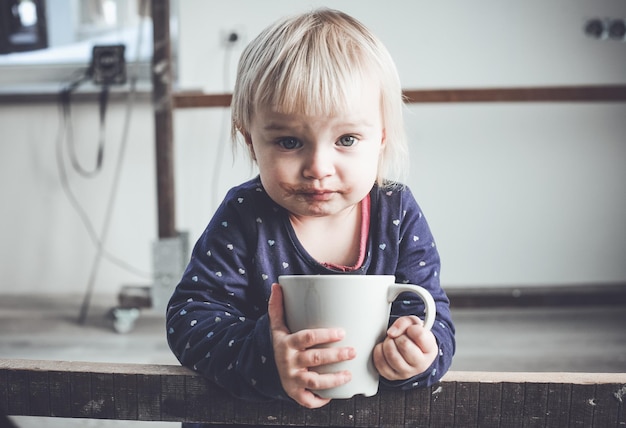 Portret van een meisje dat warme chocolade uit een beker drinkt