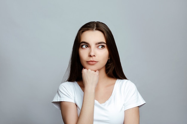 Portret van een meisje dat weg op een witte achtergrond kijkt