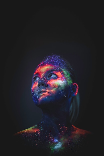 Portret van een meisje geschilderd in fluorescerende UV-kleuren.