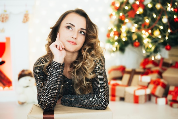 Portret van een meisje in een avondjurk op de achtergrond van kerstversieringen