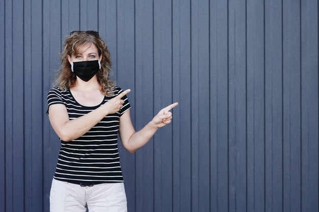 Portret van een meisje in een beschermend masker tegen een blauwe muur