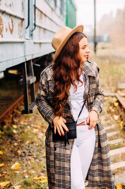 Portret van een meisje in een geruite jas en hoed tijdens een wandeling