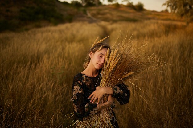 portret van een meisje met een boeket wilde bloemen jong meisje loopt over het veld bij zonsondergang