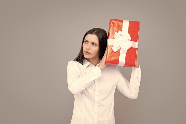 Portret van een meisje met geschenkdoos geïsoleerd over grijze achtergrond Vrouw met cadeau aanwezig