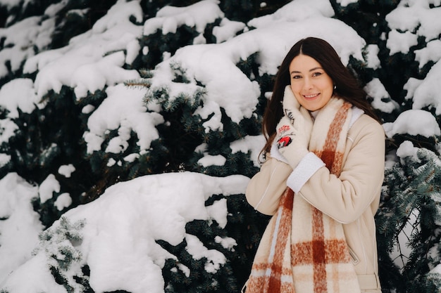 Portret van een meisje met lang haar in wanten in een winterbos Besneeuwde winter