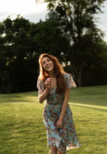 Portret van een meisje met sproeten en rood haar. zonsondergang. vrolijk meisje bij zonsondergang van de dag. zomerjurk en vrolijke stemming. portret van een meisje. unieke uitstraling