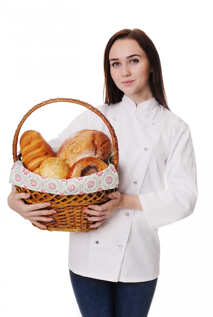 Portret van een meisjesbakker die een mand van vers gebakken brood op een witte achtergrond houdt.