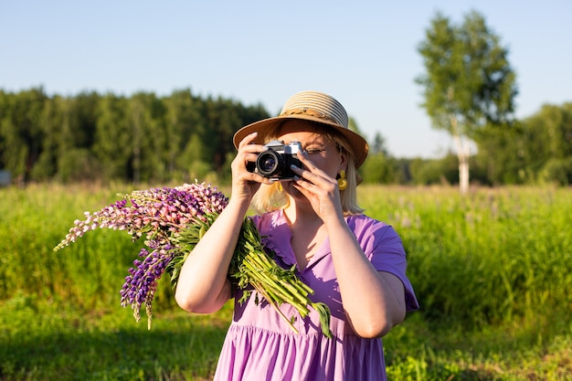 Portret van een meisjesfoto in een bloeiend veld in de zon bij zonsondergang