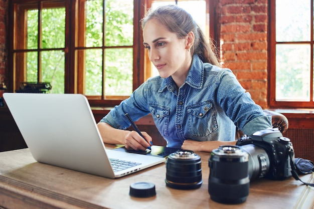 Portret van een meisjesfotograaf die met een computer werkt