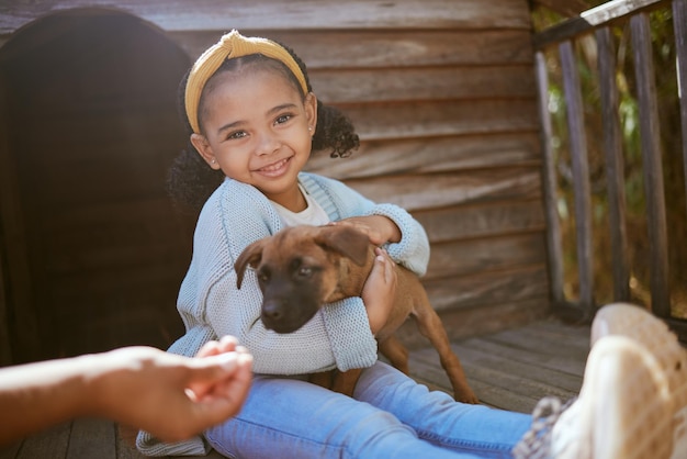 Foto portret van een meisjeskind met puppy blij buiten en opgewonden terwijl ze de hond buiten knuffelen liefde voor groei en ontwikkeling voor kinderen met huisdier in huis leuk leren zorg en verantwoordelijkheid tijdens het spelen