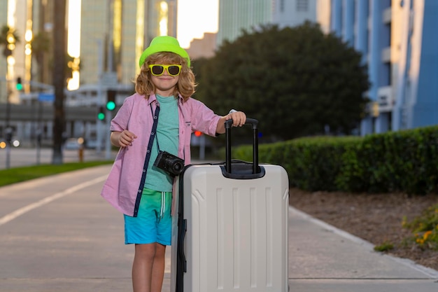 Portret van een moderne kindjongen met bagagekoffers die op vakantie gaan Kinderen reizen levensstijl Little