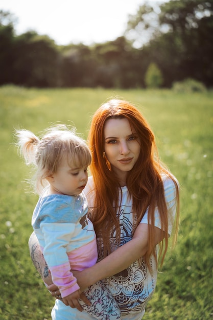 Portret van een moeder die haar dochter in het park draagt