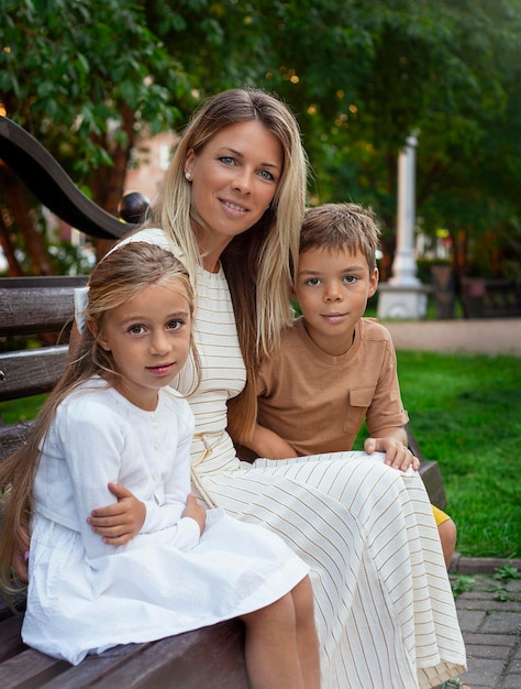 Foto portret van een moeder en twee kinderen op een bankje in het park