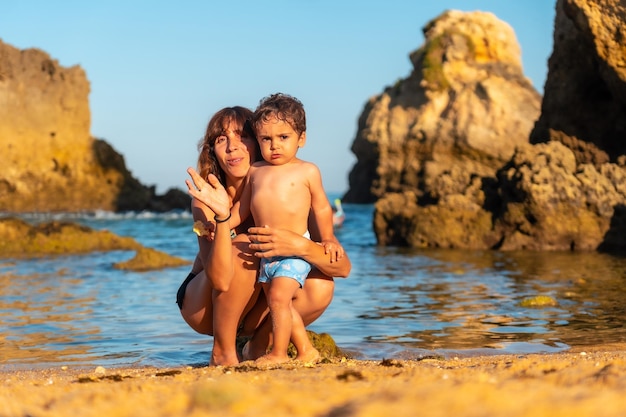 Portret van een moeder met haar zoon op Praia dos Arrifes Algarve strand Albufeira Portugal