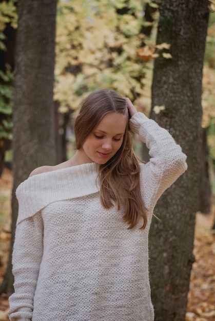 Portret van een mooi, dromerig en gelukkig meisje met lang golvend haar in de gebreide sweaterherfst. Mooi weer