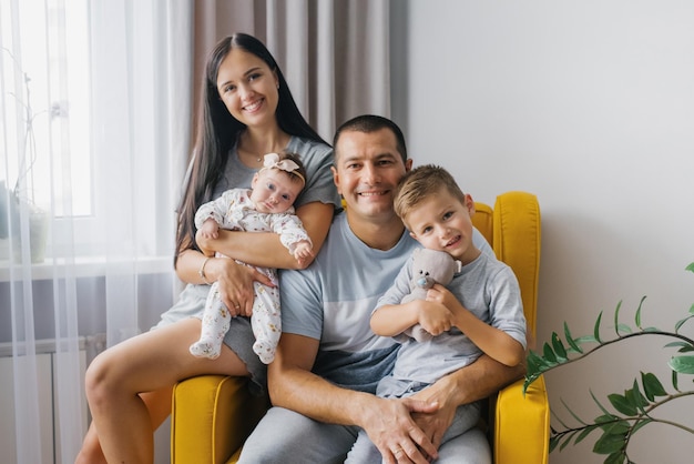 Portret van een mooi gelukkig gezin met twee kleine kinderen in hun gezellige huis