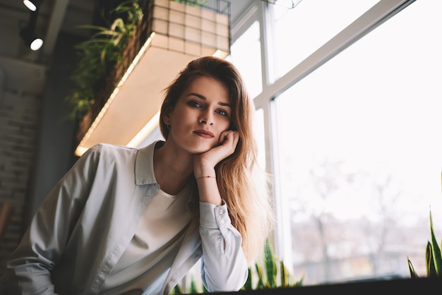 Portret van een mooi jong Kaukasisch vrouwelijk model dat binnen zit en vrije tijd doorbrengt