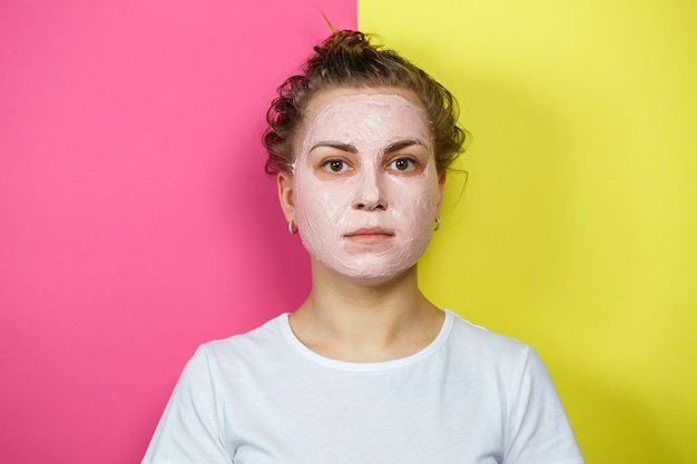 Portret van een mooi jong meisje dat een verfrissend masker op haar gezicht zet om de huid te verjongen en te versterken. Schoonheidsbehandelingen