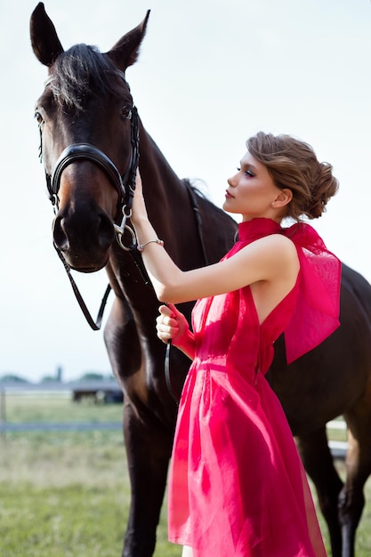 Portret van een mooi jong meisje in een jurk met een paard