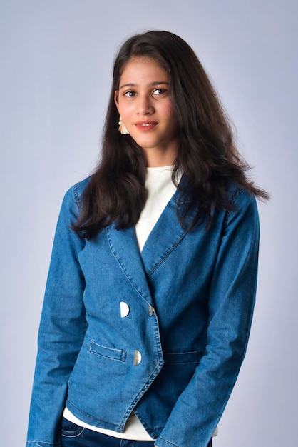 Portret van een mooi jong meisje of vrouw in een modieus pak op een grijze achtergrond Zakelijke kleding