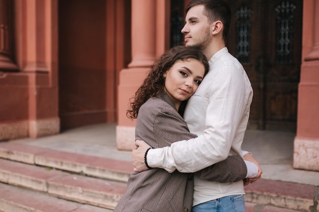 Portret van een mooi jong stel dat buiten loopt Hansomen man met aantrekkelijke vrouw in de stad Moman met krullend haar Ruimte voor tekst