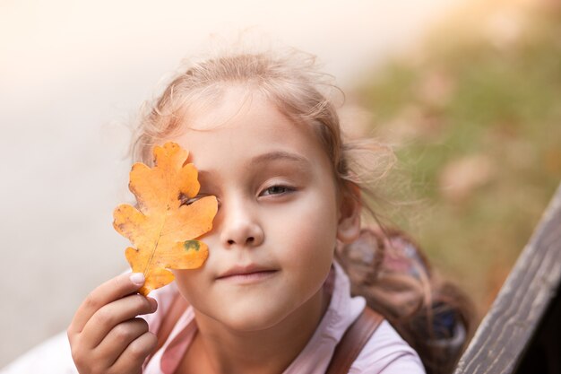 Portret van een mooi klein meisje in de herfst in het park